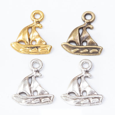 Grouped front view of small sailboat charms in the available finishes