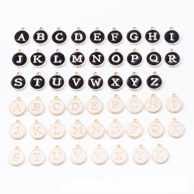 Round letter charms with contrasting A-to-Z enamel faces arranged together on a white background.