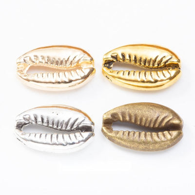Grouped front view of cowrie shell bead showing a ridged opening and rounded shell form