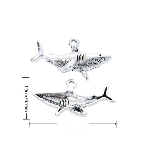 Side-profile shark charm with fins, gill lines, and textured body shown in arranged finish comparison