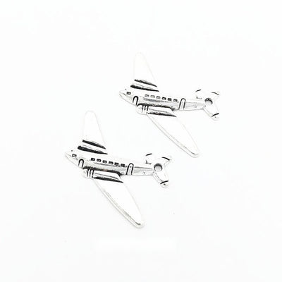 Airplane metal charm displaying front and reverse sides