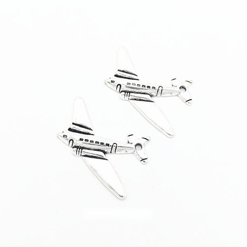 Airplane metal charm displaying front and reverse sides