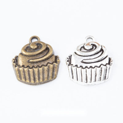 Assorted cupcake charms arranged together on a white background