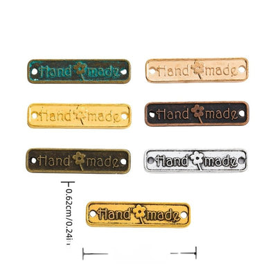 Grouped front view of handmade tag showing embossed lettering, a flower motif, and two holes