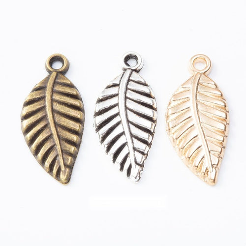Grouped front views of the veined leaf metal charm in three metallic finishes