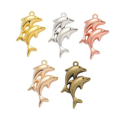 Three Dolphin Metal Charms in Five Metallic Finishes in multiple metallic finishes displayed together on a white backgro
