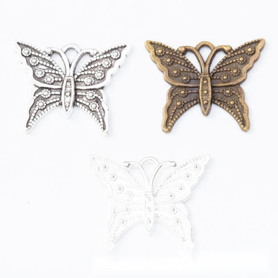 Ornate Openwork Butterfly Metal Charm Pendant shown in the available visible finishes