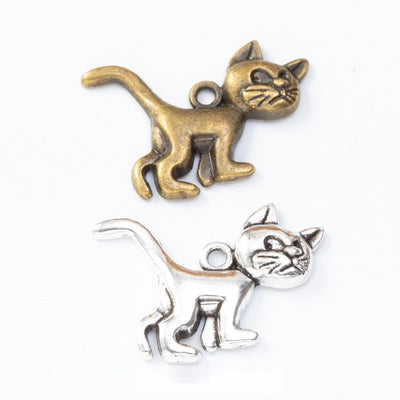 Grouped front views of the walking cat pendant charm in two antique metal finishes