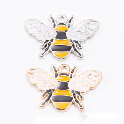 Assorted striped enamel bee charms arranged together on a white background