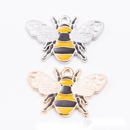 Assorted striped enamel bee charms arranged together on a white background