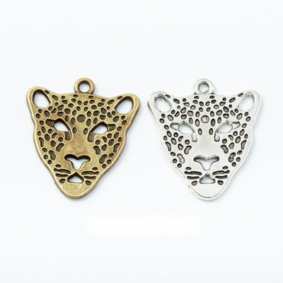 Assorted leopard head charms arranged together on a white background