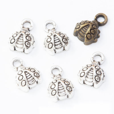 Grouped front view of domed beetle charms in the available finishes