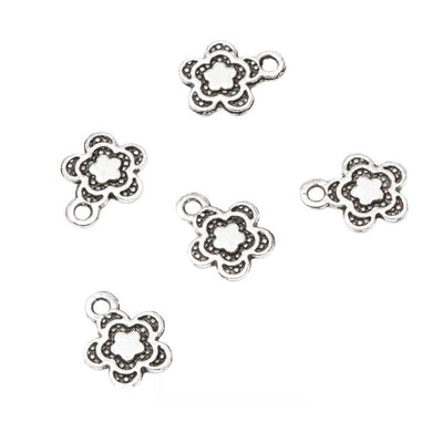 Group view of tiny five-petal flower outline with dark recessed accents
