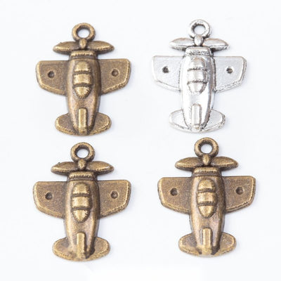 Assorted small airplane charms arranged together on a white background