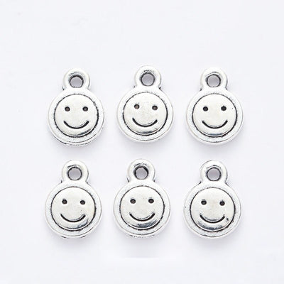 Grouped front views of the round smiley face charm in available finishes