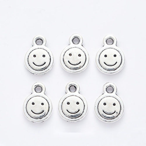 Grouped front views of the round smiley face charm in available finishes