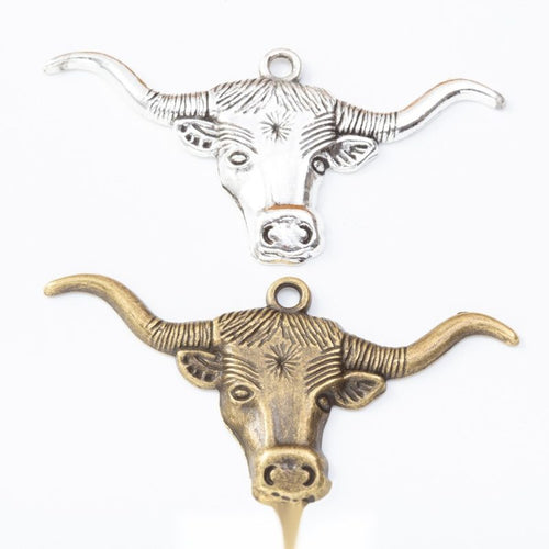 Longhorn cattle head metal component, grouped front view on white