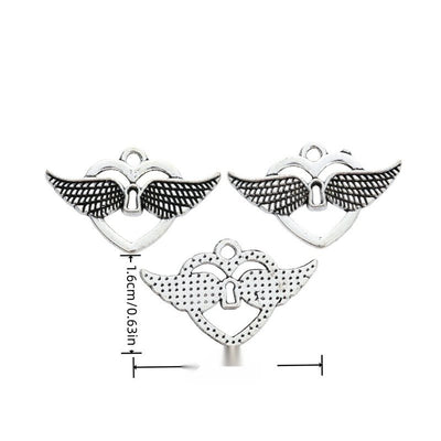 Open heart charm with spread wings and a small keyhole shown in arranged finish comparison