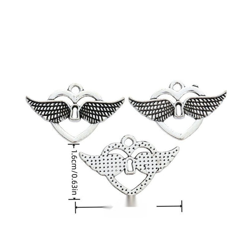 Open heart charm with spread wings and a small keyhole shown in arranged finish comparison