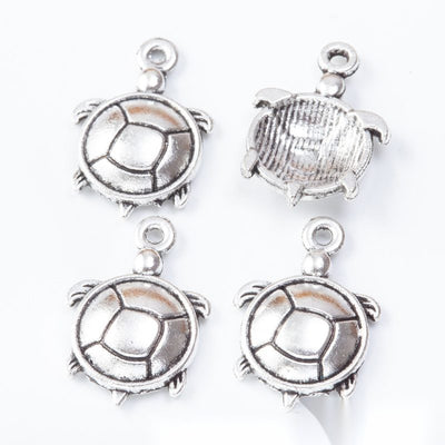 Round turtle connectors with open shell rings and lower hanging loops arranged together on a white background.