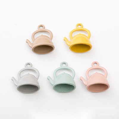 Grouped front view of pastel teapot charms in the available finishes