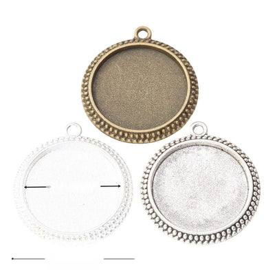 Assorted round cabochon pendant settings arranged together on a white background