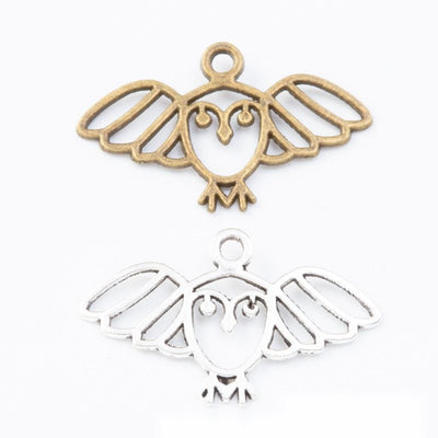 Product view of wide owl charm showing a wide openwork owl with extended wings, a heart-shaped face, and a top loop