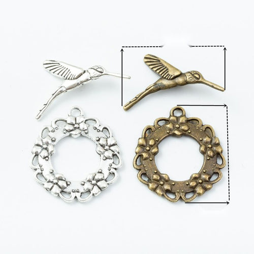 Assorted bird and wreath toggle clasps displayed together on a white background