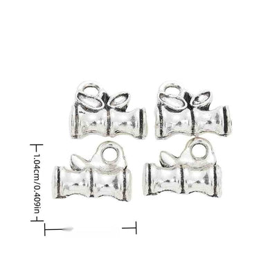 Grouped front views of the graduation cap and open book charm in available finishes
