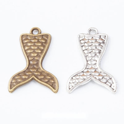 Group view of the whale tail charm showing the available finishes and front details