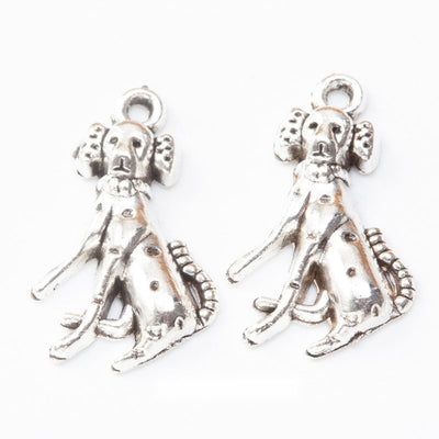 Sitting spotted dog metal component, grouped front view on white