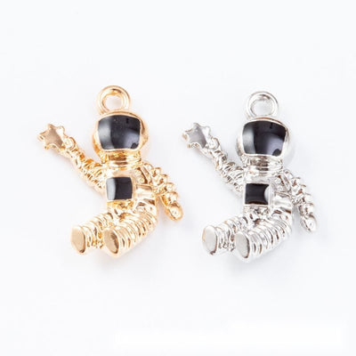 Astronaut charms with black visors and white suit details arranged together on a white background.