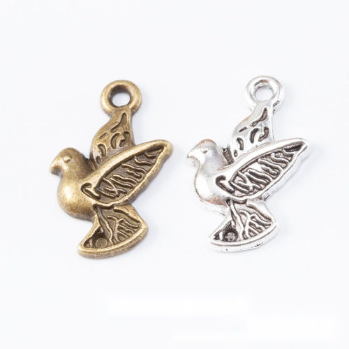 Product view of peace dove charm showing a side-view dove carrying an olive branch with engraved wing details and a top 