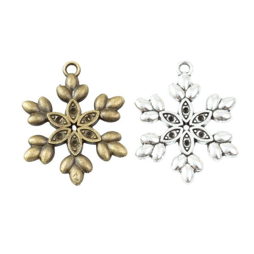 Assorted antique bronze and antique silver detailed six arm snowflake charm pieces on white