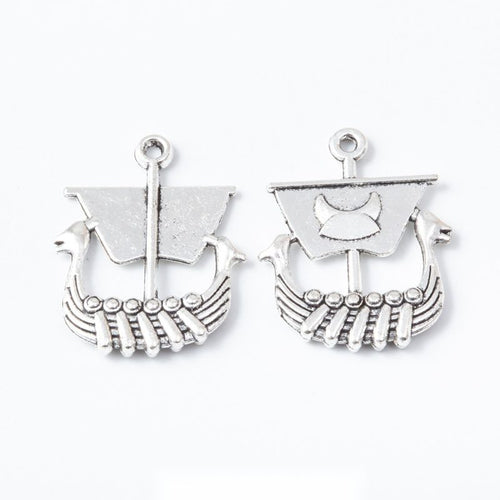 Product view of Viking longship charm showing a Viking-style longship with a square sail, curved hull, rows of oars, and