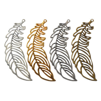Assorted openwork feather charms arranged together on a white background
