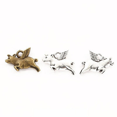Front comparison of flying winged pig metal component in 2 finishes