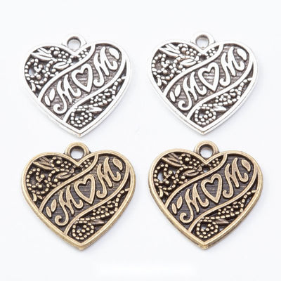 Heart charms with embossed MOM lettering and decorative scrollwork arranged together on a white background.
