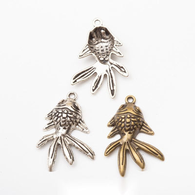 flowing tail goldfish metal charms in two finishes shown together in the available finishes
