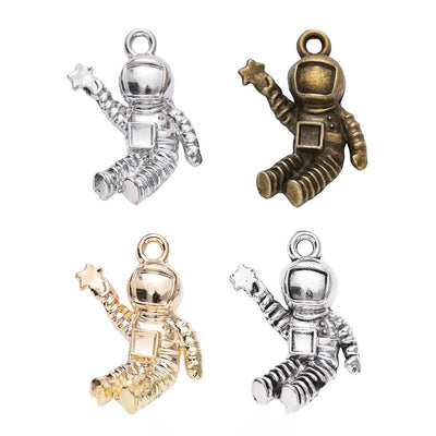 Floating astronaut charms with ribbed suits and dark visor details arranged together on a white background.