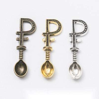 Product photo 1 of the shovel handle spoon charm highlighting its tiny spoon bowl and shovel-shaped openwork handle