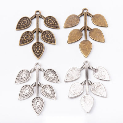 branch and leaf metal charms in two antique finishes shown together in the available finishes