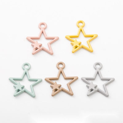 Product view of open star charm showing an open five-point star with a smaller raised star accent