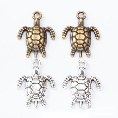 Small sea turtle charms with lattice-patterned open shells arranged together on a white background.