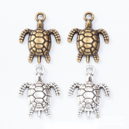 Small sea turtle charms with lattice-patterned open shells arranged together on a white background.