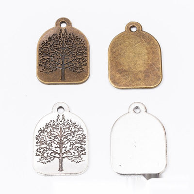 rectangular tree of life metal charms in two finishes shown together in the available finishes