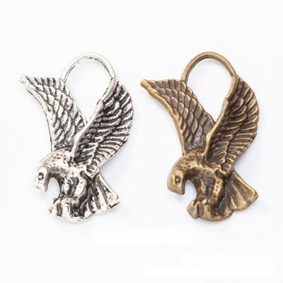 Product view of flying eagle charm showing a flying eagle with spread feathered wings, curled talons, and an arched top 