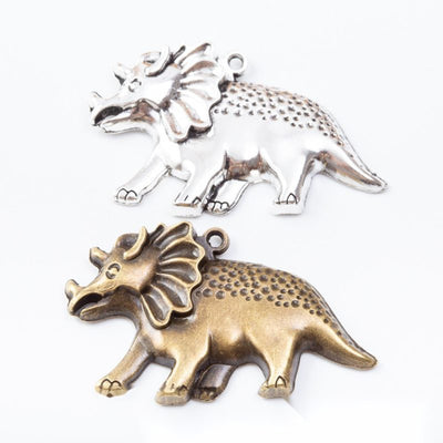 Side-profile triceratops charms with textured bodies arranged together on a white background.