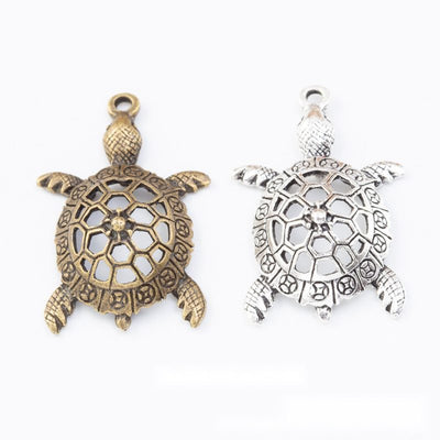 Group view of the sea turtle charm showing the available finishes and front details
