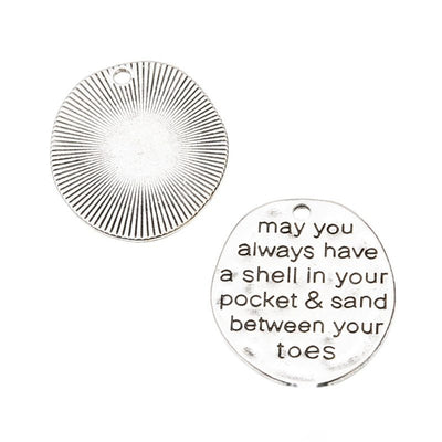 Round Pocket and Sand Quote Metal Charm in antique silver displayed together on a white background.